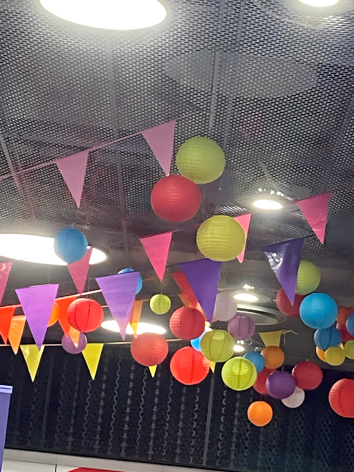 Koristelu tuo juhlan tuntua – tapahtumatuotanto Helsinki Värikkäät koristeet kauppakeskuksen katossa tapahtuman aikana Helsingissä.